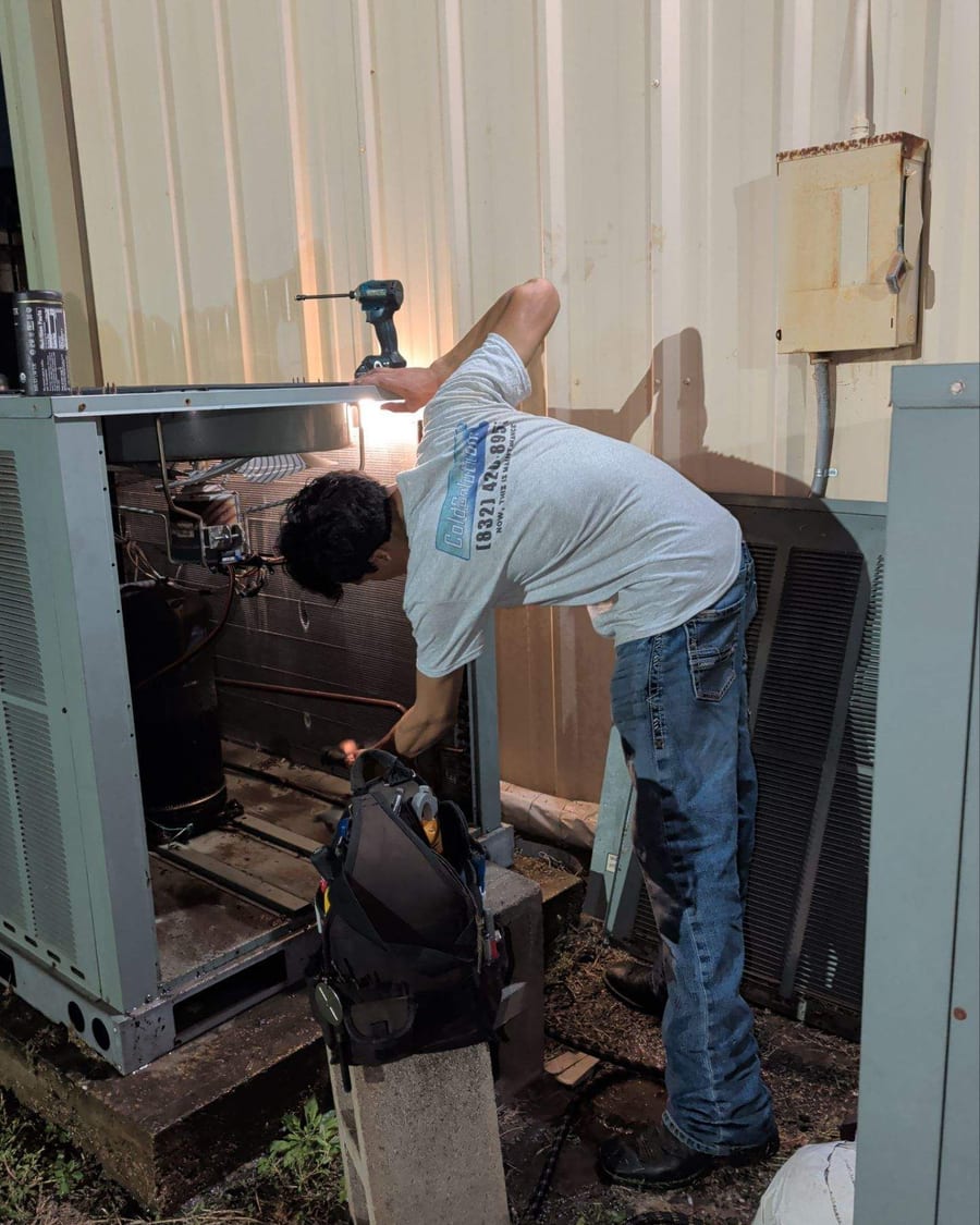 Technician working inside the cabinet of a package unit