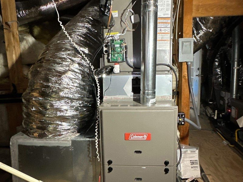New furnace and coil standing in an attic with insulated ducts