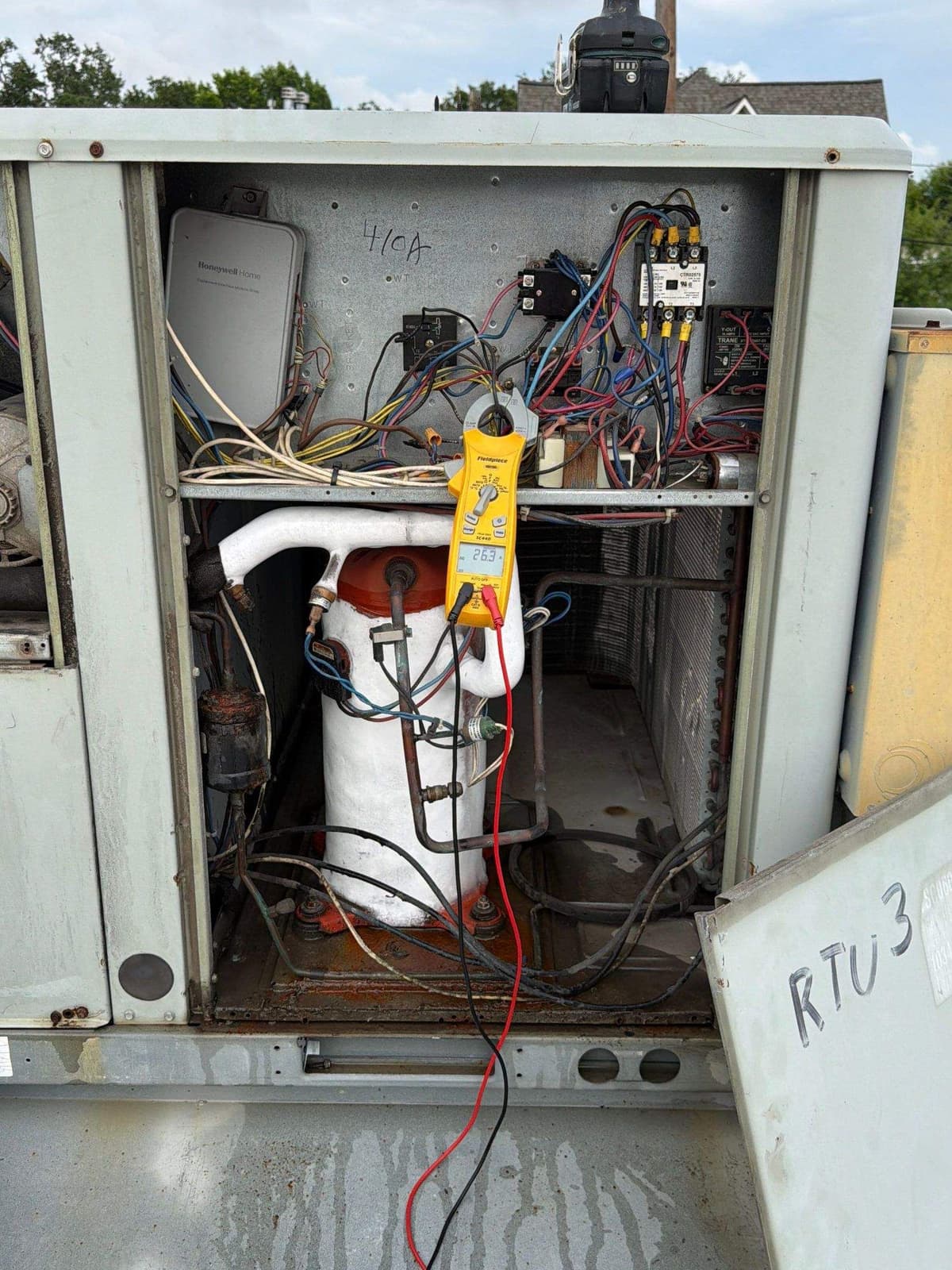 Rooftop commercial unit open for service with its wiring in view