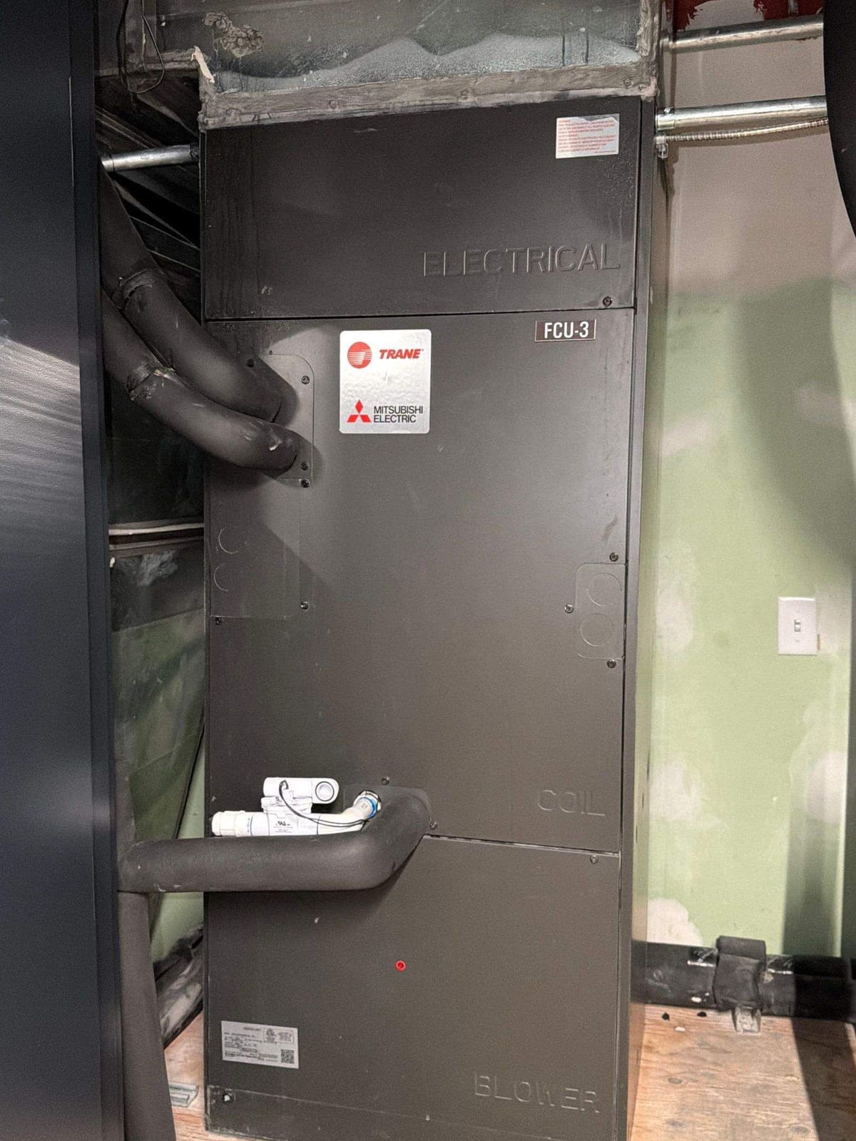 Commercial air handlers on stands in a mechanical room