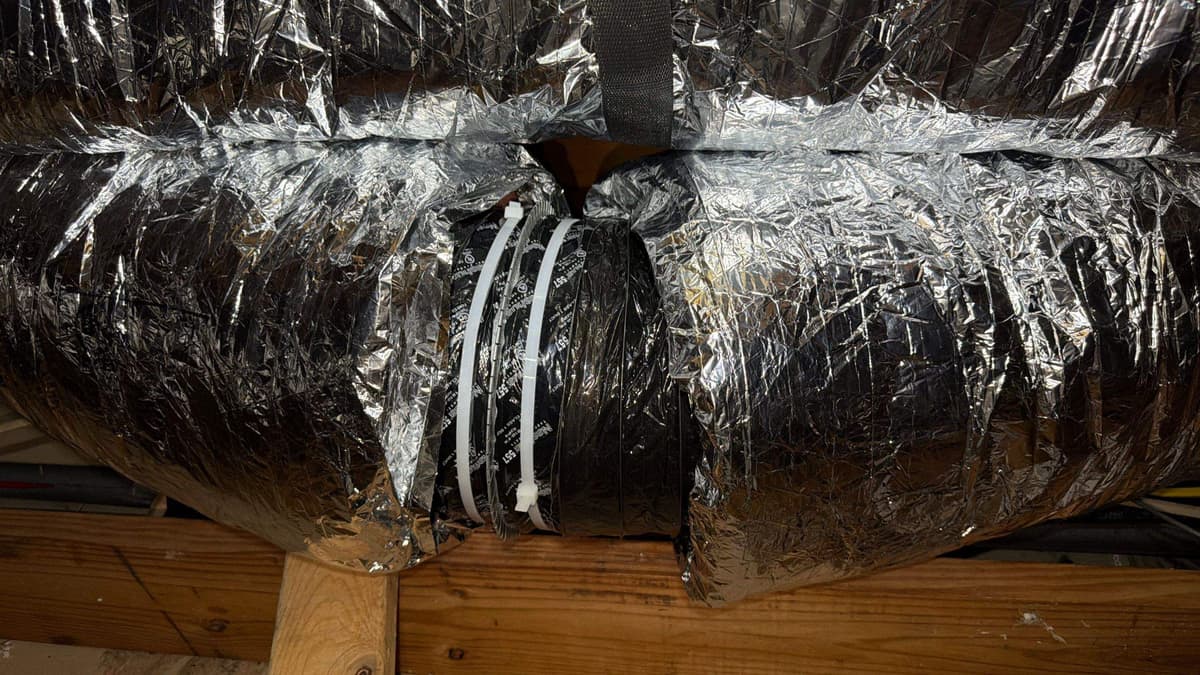 Insulated flex duct runs across an attic floor