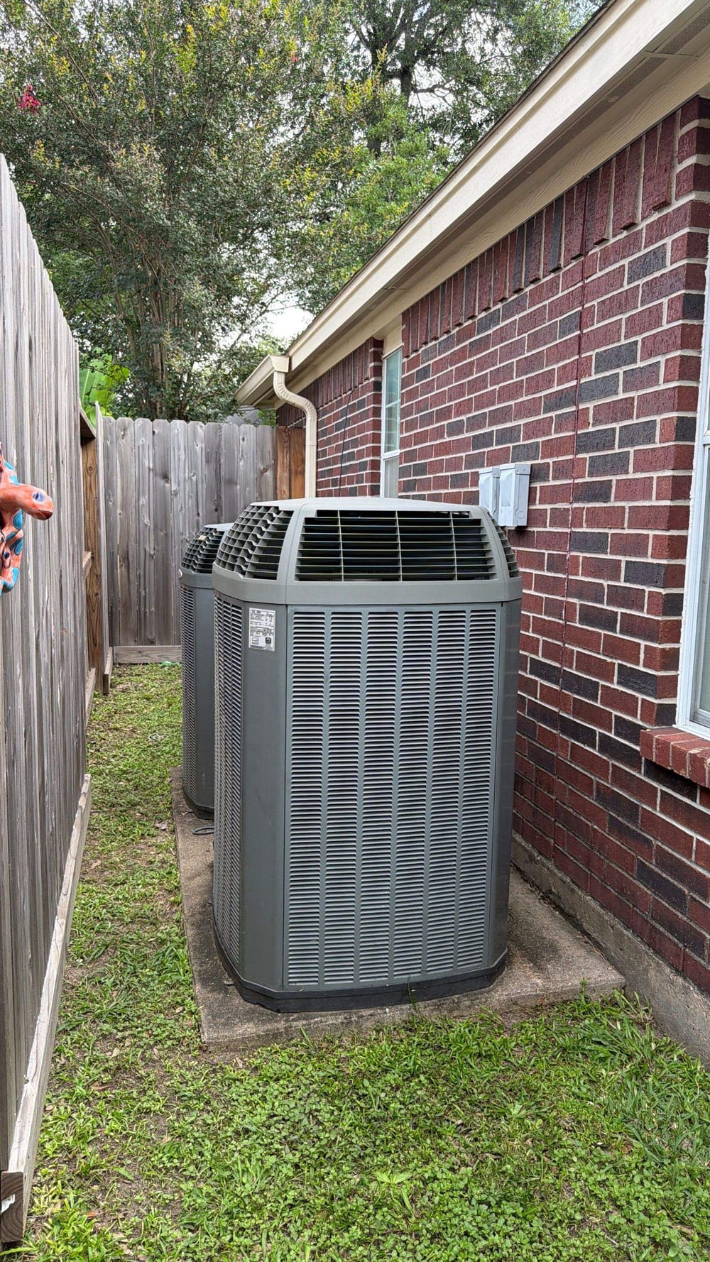 New air conditioning condenser installed by ColdSolutions beside a Houston brick home