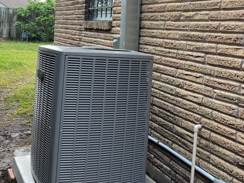 Outdoor condenser on a raised pad beside a brick home